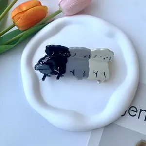 Dettaglio molletta per capelli in acetato con triplo motivo di fiori e animali nero grigio