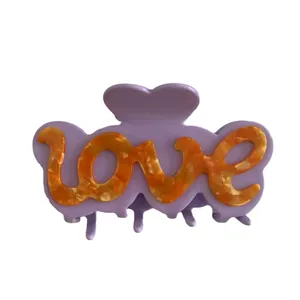 Purple acetate hair claw clip with orange marbled Love lettering in wavy Korean style