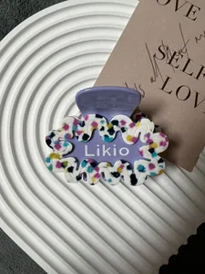 Dettaglio della pinza per capelli lavanda con trama a terrazzo colorata e design a onde