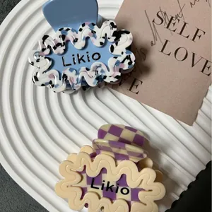 Pinze per capelli ondulate in acetato con motivi tie-dye blu e scacchiera viola