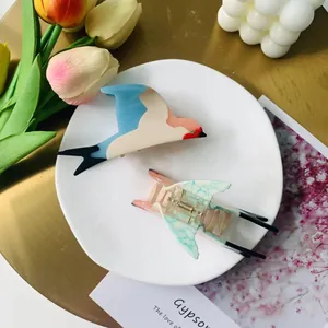 Detailed close-up of bird-shaped acetate hair claws in a decorative aesthetic setting