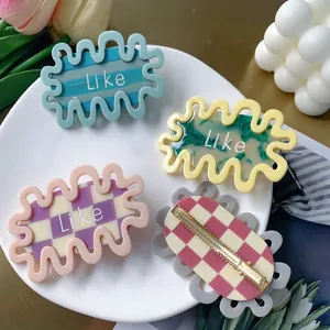 Colorful wavy acetate hair clips with Like letters in blue, purple, and green patterns