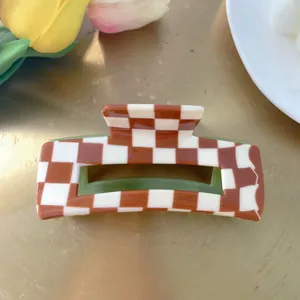 Detail of red-brown checkered hair claw with olive green interior and sturdy grip