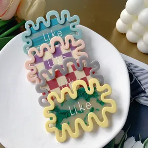 Set of four wavy acetate hair clips with geometric patterns and Like letters