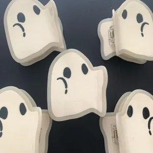 Detailed close-up of ghost-shaped acetate hair claws with spooky expressions