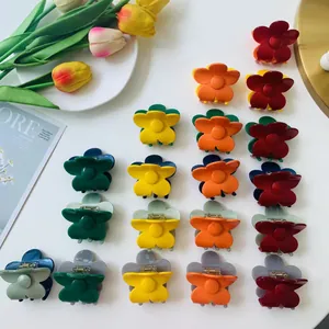 Floral hair claw clips in various colors arranged neatly on a minimalist white desk
