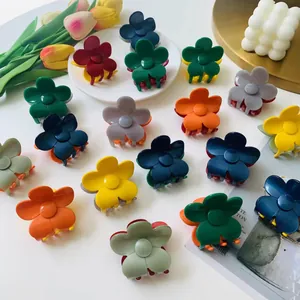 Matte flower hair claws in multiple colors arranged with tulips on a white background