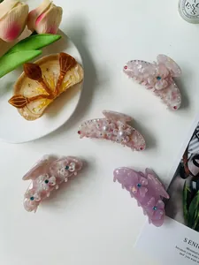 Detailed close-up of acetate hair claws featuring 3D flowers and pearl embellishments
