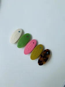 Détail de barrettes en résine colorée avec texte en relief et strass scintillants