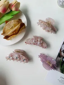 Collection of acetate hair claws in amber and pink shades with pearl flower details