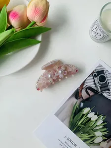 Close-up of pink marble acetate hair claw clip with 3D flowers and faux pearls