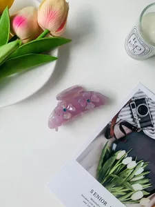 Detailed view of a purple acetate hair claw with 3D floral accents and rhinestones