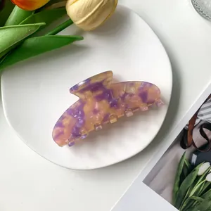 Détail d'une pince à cheveux de 9cm effet marbre violet avec tulipes en arrière-plan