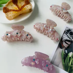 Chic acetate hair claws in various marble patterns with pearl and floral accents