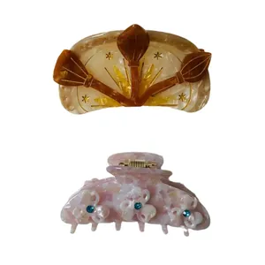 Acetate hair claws with marble pattern featuring amber broom design and pink floral accents