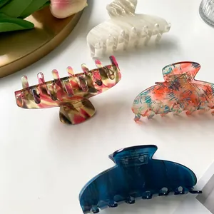 Set of four elegant acetate hair claws with marble and checkerboard patterns on white