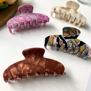 Set of four stylish acetate hair claws with various marble patterns and artistic textures