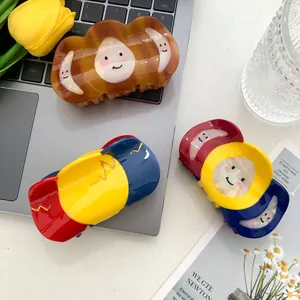 Tres pinzas grandes para el cabello en carey y tricolor sobre un ordenador