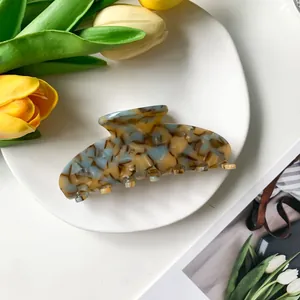 Detalle de una pinza para el pelo de acetato con mármol azul y ámbar elegante