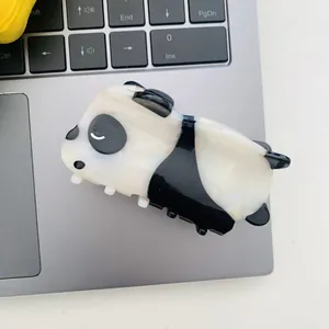 Détail d'une pince à cheveux panda mignonne en acide acétique sur fond d'ordinateur