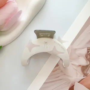 Detalle de pinza para el pelo luna blanca con estrellas rosas y cristales brillantes