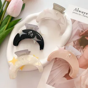 Set de pinzas para el cabello con forma de luna y estrellas sobre bandeja blanca