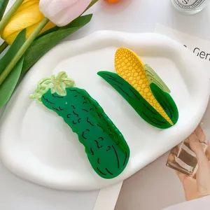 Creative corn and cucumber hair claw clips set on a stylish white decorative tray