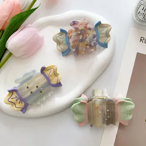Candy-shaped acetate hair claw clips with rhinestones in pastel blue, yellow and pink