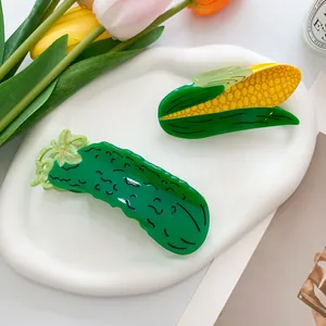 Creative corn and cucumber shaped hair claw clips on a white ceramic display tray
