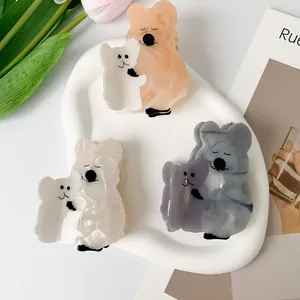 Cute koala acetate hair claws in white orange and blue marble textures on a white tray