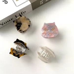 Cute cat-shaped acetate hair claws in four colors shown on a minimalist white background