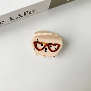 Detail of cute puppy claw clip featuring red heart glasses and acetate glossy finish