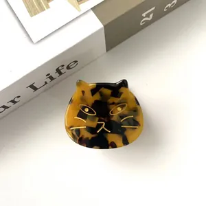 Detailed close-up of a tortoiseshell cat claw clip with gold accents and acetate texture