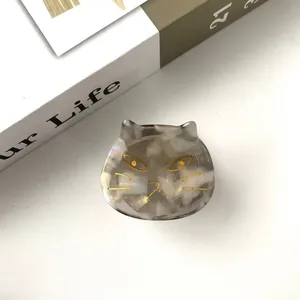 Detailed macro view of the cat-shaped acetate hair claw with marble texture and golden details