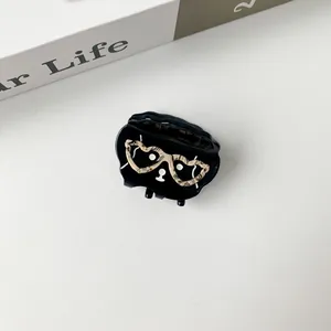 Close-up of black cat hair claw clip with heart shaped leopard print glasses design