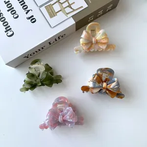 Elegant set of four acetate hair claws with triple-layer bow design in marble patterns