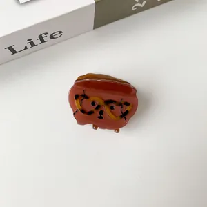 Close-up of brown acetate hair claw with funny dog face design and leopard print glasses