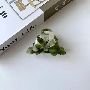 Deep green marble acetate hair claw clip with triple bow design on white background