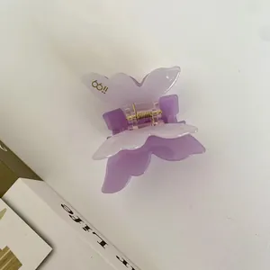 Detailansicht der Schmetterling Haarklammer aus Acetat in Lila und Weiß mit Goldfeder