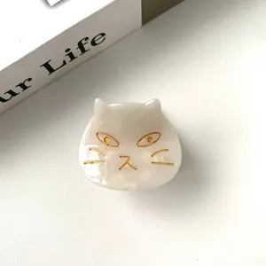 Macro view of white cat hair claw made of acetate with elegant gold face details