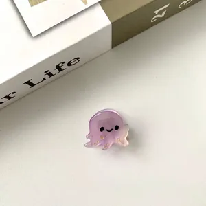 Vue détaillée d'une mini pince à cheveux pieuvre violette en acétate avec des paillettes dorées