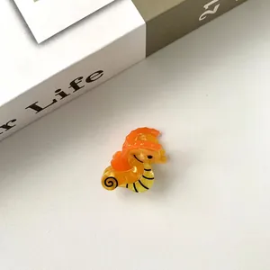 Vue rapprochée d'une mini pince à cheveux hippocampe en acétate jaune brillant