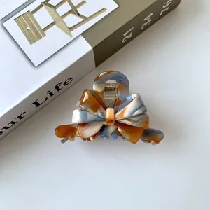 Macro shot of marble textured acetate hair claw clip with elegant metal spring detail