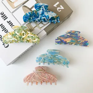 Large acetate hair claws with marble and floral patterns for elegant hairstyling