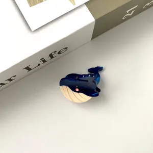Vue de dessus d'une jolie pince à cheveux baleine bleue et beige en acétate sur fond style