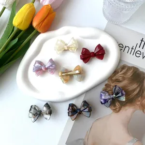Pinzas para el pelo con lazo de acetato jaspeado mostradas con accesorios de moda