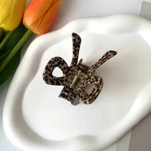 Détail d'une pince à cheveux à motif écailles de tortue posée sur un plateau blanc