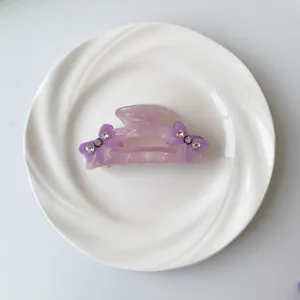 Detail einer violetten Marmor-Haarklammer mit Schleife und funkelnden Strasssteinen