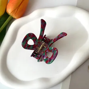Détail de la pince à cheveux papillon en acétate coloré avec ressort en métal doré