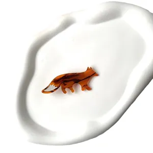 Barrette à cheveux renard en acétate écaille ambrée sur un plateau en céramique